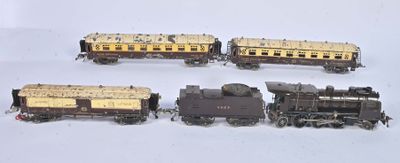 quatre petits trains miniatures posés sur une surface blanche, avec un fond blanc