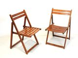 deux chaises pliantes en bois placées l'une à côté de l'autre