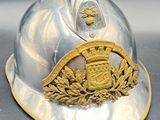 a silver helmet with a gold emblem on it