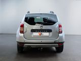 the rear end of a silver car parked in a white room