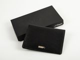 un portefeuille en cuir noir posé sur une boîte noire