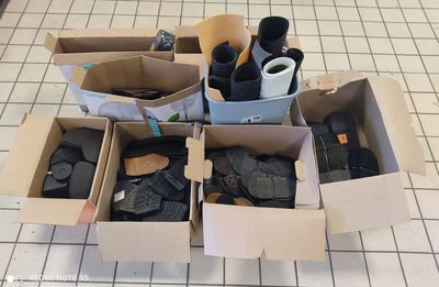 plusieurs cartons contenant divers objets, posés sur un sol carrelé