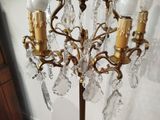 a gold colored chandelier with crystal drops hanging from it