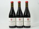trois bouteilles de vin rouge posées côte à côte sur une table
