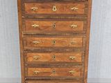 a wooden chest of drawers with marble top and brass handles
