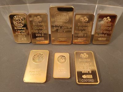 cinq lingots d'or dans une vitrine posée sur une table