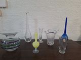 de nombreux vases en verre posés sur une table en bois