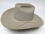 the hat is tan and has a brown ribbon around the brimle