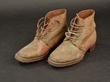 an old pair of brown boots with laces on them on a black surface