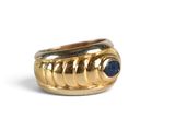 a close up of a gold ring with a blue stone