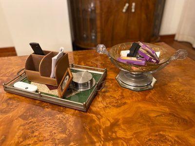 a wooden table with a glass bowl on it and a cell phone on it