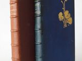 an old book with a blue cover and a brown book with a flower on it