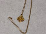 a close up of a gold necklace with a small eye on it