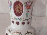 un vase blanc orné d'un motif rouge et or