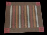 a close up of a brown and red rug on a black background