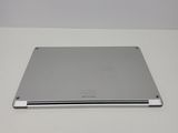 the back of a silver laptop computer sitting on top of a white table