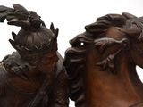 a statue of a man riding a horse with a helmet on