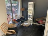 un salon avec un canapé, des fauteuils et une table basse