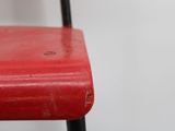 a red chair with a black metal frame and a red seat