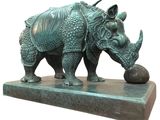 statue of a rhinocer with a ball on a marble base