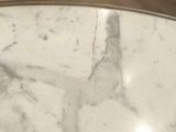a close up of a marble table top on a wooden floor