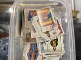 un récipient en plastique rempli de timbres posé sur une table