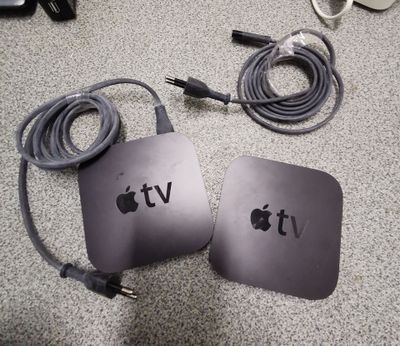 two apple tvs sitting next to each other on the floor