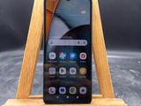 un gros plan d'un téléphone portable posé sur un support en bois, sur une table