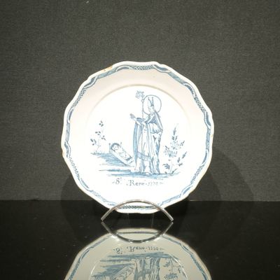 a blue and white plate with a picture of a man and a dog on it