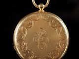 an antique gold pocket watch on a black background with a black background