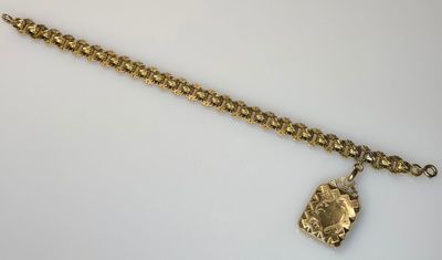 a close up of a gold chain bracelet with a coin on it
