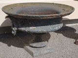 a rusted metal bowl sitting on the ground