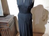 une robe noire posée sur un présentoir à mannequin dans une pièce