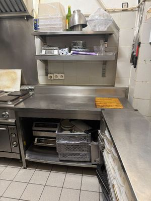 une grande cuisine en inox équipée d'une cuisinière et d'un évier