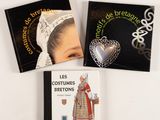 trois livres posés sur une table blanche, avec la photo d'une femme en robe portant une broche en forme de cœur