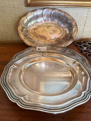 deux assiettes en argent posées sur une table en bois, avec une paire de ciseaux