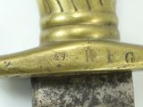 a close up of a gold colored sword with a black handle