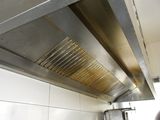 a metal vent in the ceiling of a commercial kitchen