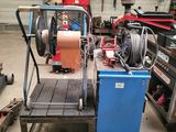 a blue cart with a hose on it in a garage