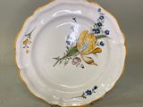 une assiette blanche décorée de fleurs jaunes et bleues