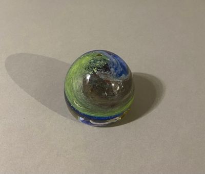 a glass ball with a green and blue design on it