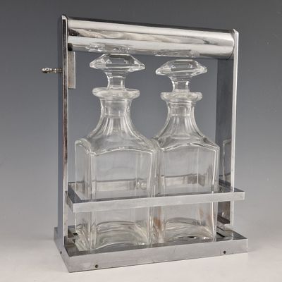 three glass bottles in a metal holder on a table