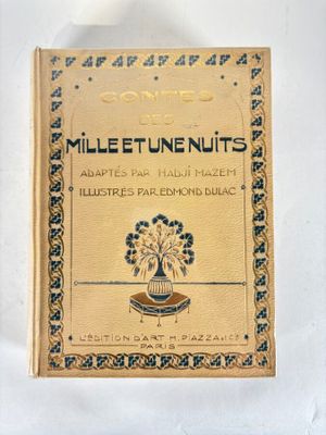 an old book with a gold cover on a white surface