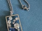 des bijoux posés sur un tissu bleu, avec une étiquette de prix