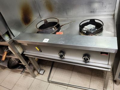 une cuisinière sur laquelle est posée une marmite dans une cuisine