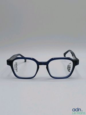 Ces lunettes sont en plastique et ont une monture noire.