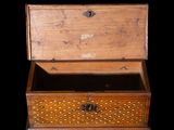 a small wooden box with a handle on a black background