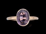 Gros plan sur une bague contenant une pierre violette
