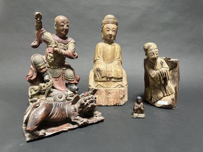 several asian figurines are displayed on a gray surface