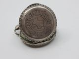 an old silver ring with a coin on it on a white surface